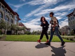 Two students walking on campus near Center of Environmental and Life Sciences