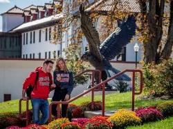 Two students sitting by the hawk statue.